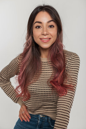 Young happy beautiful woman with a smile and freckles with pink hair in a trendy fashion sweater on a white backgroundの写真素材