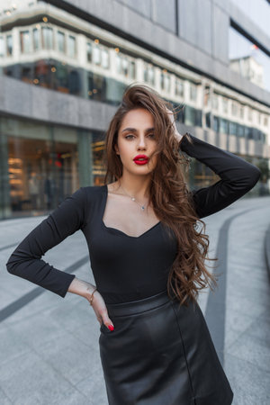Fashionable beautiful sexy elegant chic lady with red lips in trendy fashion black clothes walking in the cityの写真素材