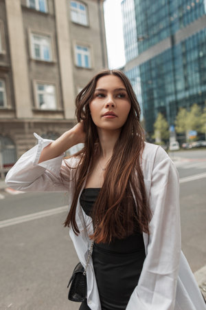 Everyday Street Style Outfit. Pretty fashion woman in black dress with white shirt in the cityの写真素材
