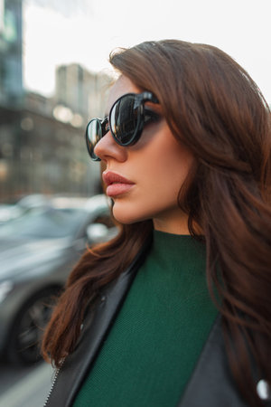 Portrait of a beautiful stylish young fresh woman model with fashion sunglasses in trendy urban casual clothes in the cityの写真素材