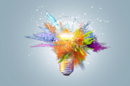 Creative concept light bulb explodes with colorful water colors on a light blue background. Think different, creative idea. productivity and creativityの写真素材
