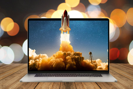 Space rocket shuttle with a cloud of smoke and blast lift off from a laptop on a working office desk with bokeh. creative idea and startup. successful business project. Rocket take off from displayの写真素材