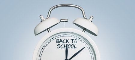 Vintage alarm clock showing back to school arrows. Beginning of the school season. Education. Students start. School and clock, conceptの写真素材