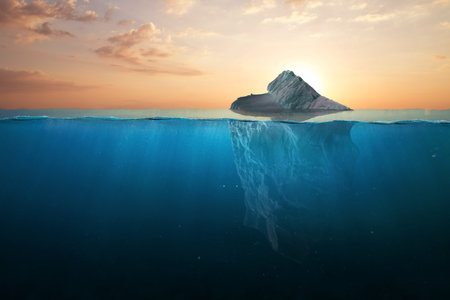 Ocean warming, concept. Iceberg in clear blue water and hidden danger under water at sunset. Iceberg - Hidden Danger And Global Warming Concept. Floating ice in the ocean. Copy space for text and design.の写真素材