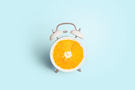 Creative vintage orange clock on a blue background, concept. Marketing and advertising, creative idea. Minimal idea business. Healthy lifestyleの写真素材
