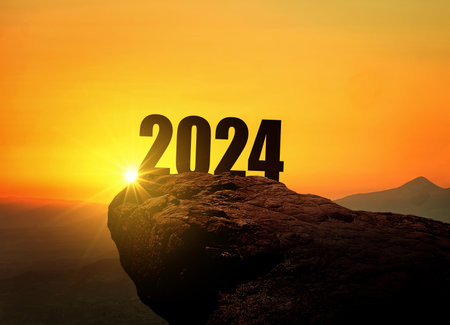 New Year 2024 at sunset. Silhouette 2024 stands on a mountain with sun rays at sunrise, creative idea. Year 2024, conceptの写真素材