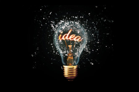 Creative idea light bulb with Idea explodes with shards of glass on a dark background. Business, ideas and new thinking. Think Different. Go beyond what is possible. Marketing. Creative thinkingの素材
