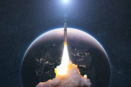 Space rocket lift off into space with smoke and blast on a background of the blue planet earth. Spacecraft flies in space with a starry sky near the planet. Successful start of the missionの素材