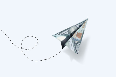 Paper dollar plane flies on a white background, creative idea. Business and finance, concept....
