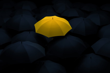 Yellow umbrella standing out among black ones, symbolizing individuality, creativity, leadership, and courage to be different in a world of conformity. Minimalist concept of uniqueness and contrast.の写真素材