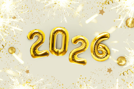 Golden luxury balloons 2026 new year with golden sparks lie on a beige table, top view. Happy New...