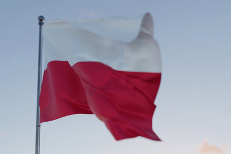 Polish national flag with red and white stripes waving in the wind on a clear sky background, symbol of patriotism, independence, and national pride of Poland.の写真素材