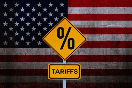 Tariffs. Yellow road sign tariffs on background of American flag, concept. Trade wars and crisis, creative idea. US Trade policy. Tariffsの写真素材