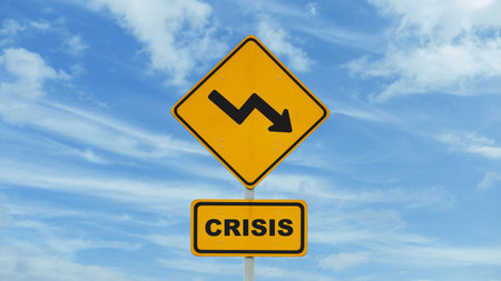 Yellow road sign crisis with arrow down on blue sky with clouds, creative idea. World economic crisis, concept. Attentionの写真素材
