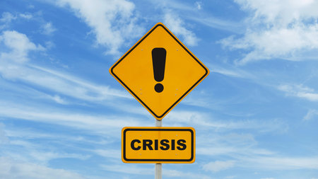 Attention crisis, concept. Yellow road sign crisis on blue sky with clouds, creative ideaの写真素材