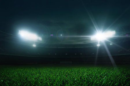 Modern football stadium with green lawn and spotlight. Soccer background. Wide-angle view of a football stadium under lights, perfect as a dynamic sports background at nightの写真素材