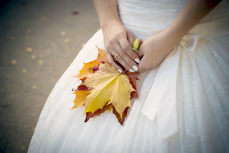 Bride holding hands by connecting them to a white dressの写真素材