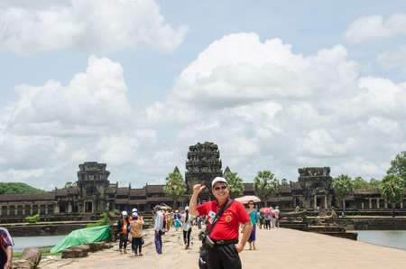 traveller thumb up and smile at Angkor wat, Cambodia- August, 24, 2013のeditorial素材