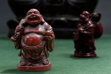 Red Laughing Buddha with sack and offering bowlの写真素材