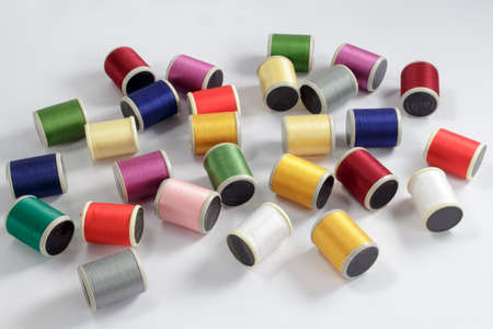 Diverse bobbins of cotton thread for sewing machines on white backgroundの写真素材