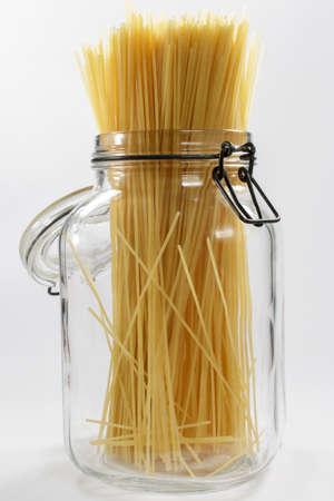 Spaghetti in a glass jar on white backgroundの写真素材