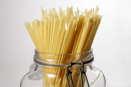 Spaghetti in glass jar isolated on white backgroundの写真素材