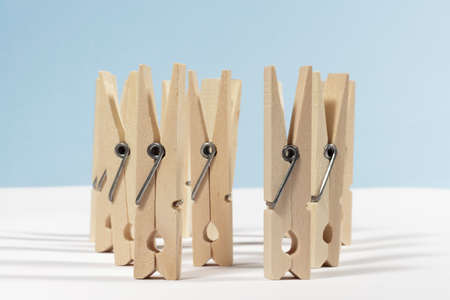 Several spring-type wooden clothespins on white floor and blue backgroundの写真素材