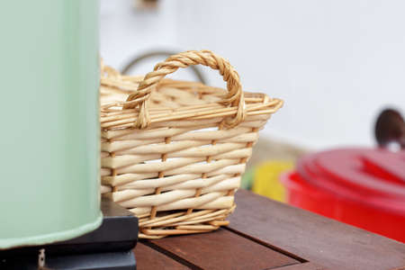 Small wicker basket behind a green metal box for crockeryの写真素材