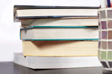 Stack of books on a wooden desk and white backgroundの写真素材