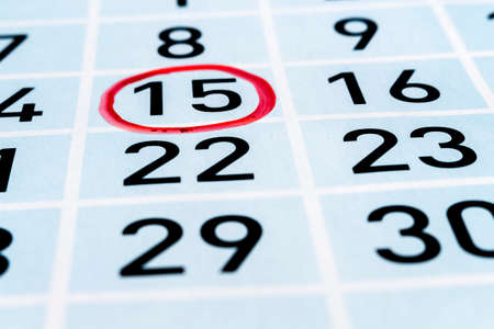 Calendar page with fifteenth day of month highlighted by red circleの写真素材