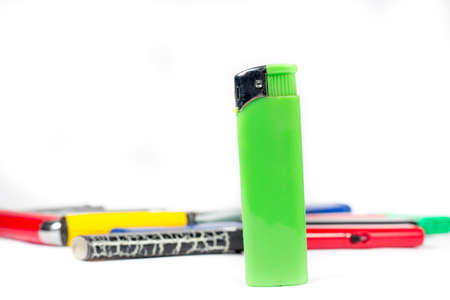 Green cigarette lighter in front of other ones, on white backgroundの写真素材