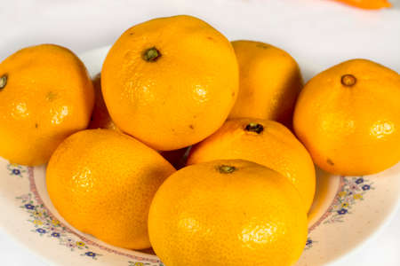 Detail view of orange tangerines into a ceramic white dishの写真素材