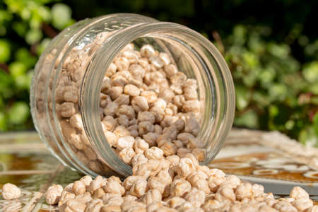 Overturned glass pot with dried chickpeasの写真素材