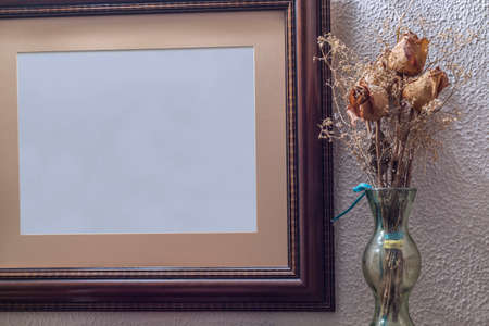 Bouquet of dried roses next to a blank canvas pictureの写真素材