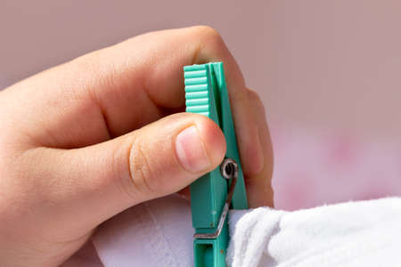 Detail of child's hand that is hanging up clothes in the clothesline. Houseworkの写真素材