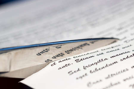 Text reflected on blade of scissors cutting a paperの写真素材