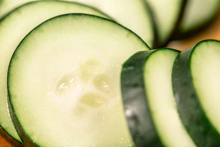 Macro view of the clear yellow flesh of several cucumber slicesの写真素材