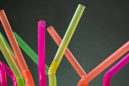 Close-up of articulated drinking straws of colors yellow, pink, orange and greenの写真素材