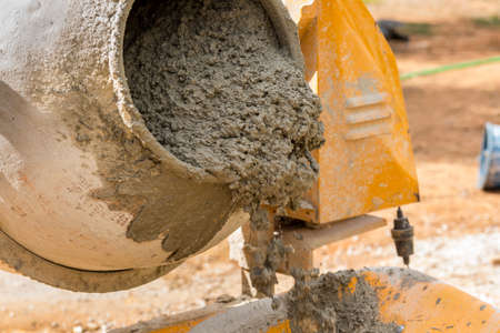 Pouring mortar from the cement mixer into a wheelbarrow. Building work
