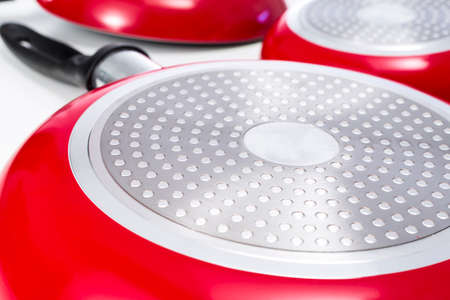 Close-up of induction bottom of a red frying pan made of aluminium