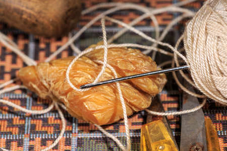 Leather needle beside shoemaker's wax and other hand toolsの写真素材