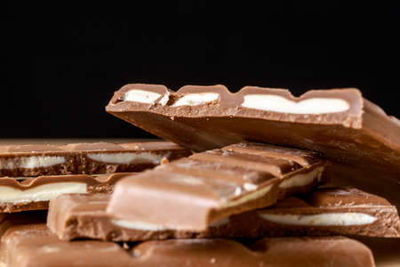 Chocolate tablets with fruit taste fillings on black backgroundの写真素材