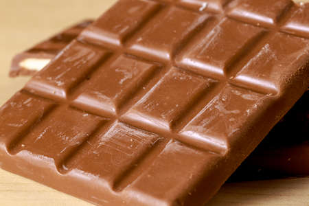 Chocolate bars with fruit taste fillings on wooden floor