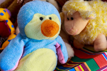 Penguin doll beside teddy sheep and other stuffed toysの写真素材