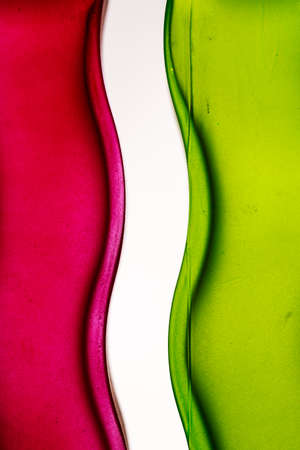 Colorful and sinuous background. Detail of curves in red and green glass surfacesの写真素材