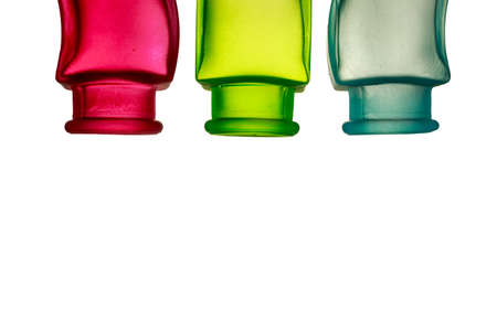 Primary colors background. Red, green and blue decorative glass jars upside dow, with blank space at bottom of the image の写真素材