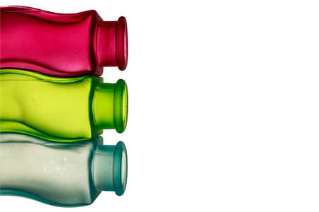 Primary colors background. Red, green and blue decorative glass jars with sinuous shape, with blank space at right of the image の写真素材