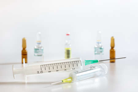 Hypodermic syringes of different sizes, on whiteの写真素材