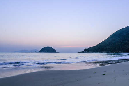 Beach before sunrise, the moon hanging skyの写真素材