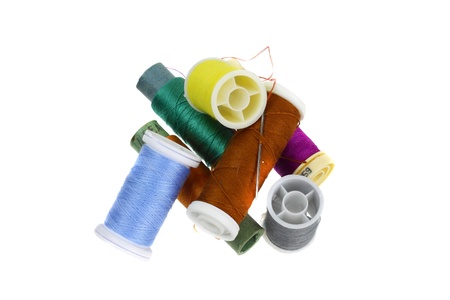 Spools of multicolored embroidery threads in the pile isolated on white